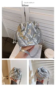 Detailed macro of silver quilted bucket bag with two-tone chain and drawstring detail