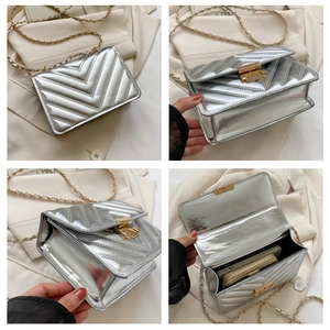 Detail view of silver quilted crossbody bag showing chain strap and interior storage capacity