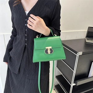 Stylish green leather trapezoid handbag with gold T-clasp and adjustable shoulder strap