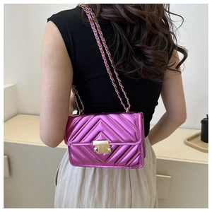 Close-up of metallic pink chevron quilted shoulder bag with golden chain and lock