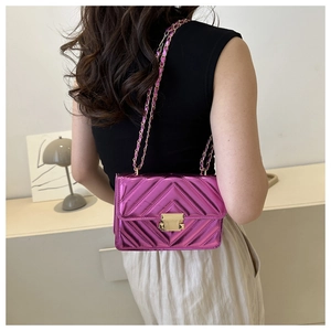 Detail of metallic purple patent leather crossbody bag with V-shaped chevron quilting