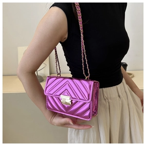 Detail of metallic purple quilted mini crossbody bag with golden chain and V-pattern