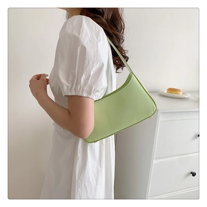Detail of mint green PU leather hobo bag styled with a white puff sleeve dress