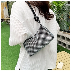 Detail of black rhinestone underarm bag with unique knotted leather shoulder strap