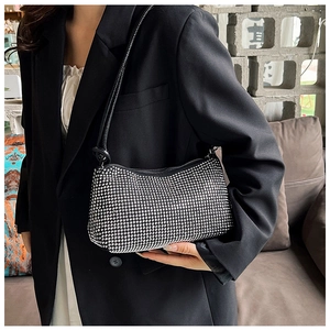 Chic black baguette shoulder bag with sparkling silver rhinestones on a female model