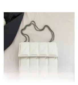 Detailed view of white quilted crossbody bag with stylish silver metal chain strap