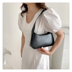 Classic black minimalist underarm bag with smooth half-moon shape and matte leather texture