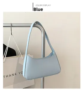 Detail view of a light blue minimalist hobo bag hanging on a silver metal rack