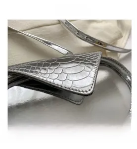 Détail macro du cuir synthétique argenté effet miroir avec gaufrage crocodile du sac