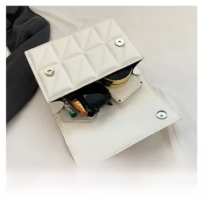 Interior view of white quilted crossbody bag showing storage for phone and makeup