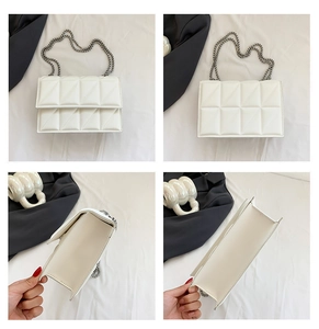 Detail view of white quilted faux leather bag with silver chain strap and large interior