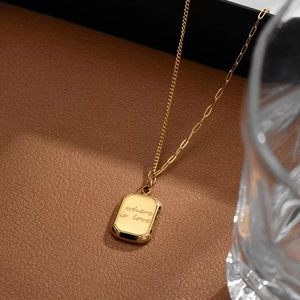 Goldene rechteckige Halskette mit where is love Gravur auf elegantem Lederhintergrund