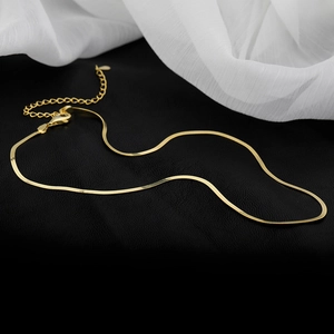 Dettaglio della collana a catena piatta a serpente dorata con chiusura a moschettone