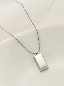 Close-up of polished silver rectangle brick pendant on a minimalist snake chain