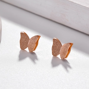 Elegant rose gold butterfly stud earrings with matte texture and 3D design on a light surface