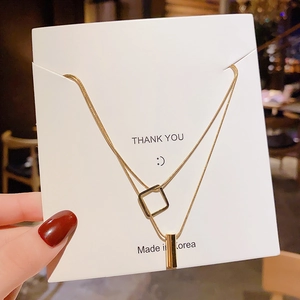 Double-layer gold titanium steel necklace featuring square and cylinder pendants