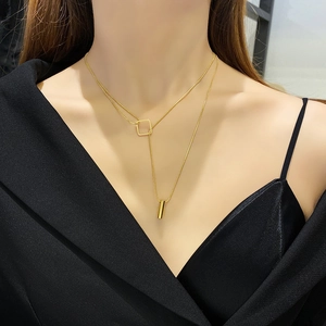Double-layered gold titanium necklace with geometric square and cylinder pendants on model