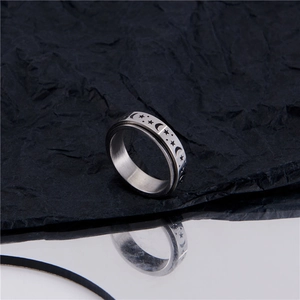 Silver stainless steel rotating ring with moon and star engraving on textured background
