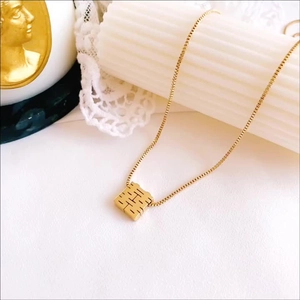 Macro shot of gold-plated Double Happiness cube pendant on a delicate box chain