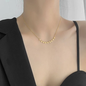Chic 18k gold plated necklace with nine small round pendants worn on a female model