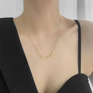 Minimalist 18k gold plated titanium necklace with small round disc pendants on a model