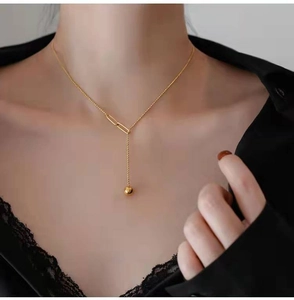 Elegant gold Y-shaped pull necklace with round bead tassel shown on female model