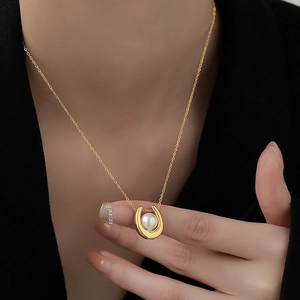 Collier luxueux avec pendentif fer à cheval en or et perle sur un mannequin femme
