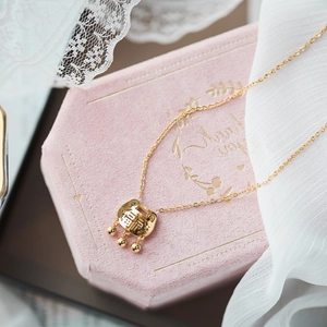 Gold Longevity Lock necklace with Fu character on pink velvet box with lace background