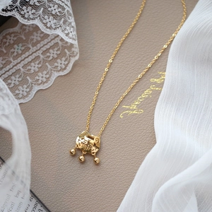 Golden longevity lock necklace with peace engraving on elegant leather and lace background