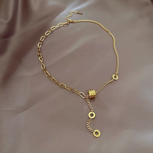 Golden asymmetrical cylinder necklace with LOVE engraved rings on dark satin