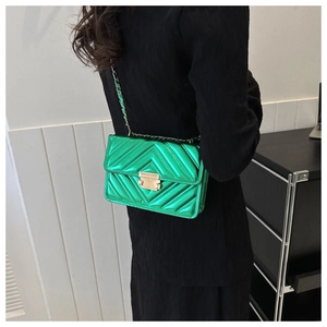 Detail of metallic green shoulder bag with V-quilt pattern and gold chain strap