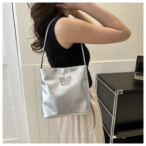 Silver metallic tote bag detail with pink butterfly embroidery and slim shoulder straps