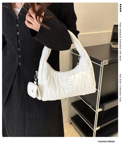 Détail du sac baguette blanc matelassé avec mini pochette et texture nuage douce