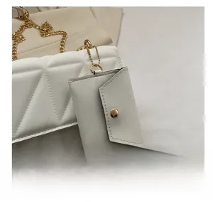 Detail der weißen Stepptasche mit goldener Kette und abnehmbarem Mini-Umschlag-Etui