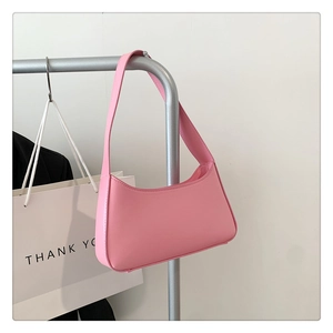 Close-up of pink synthetic leather hobo bag with minimalist design on metal hanger