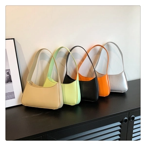 Five minimalist hobo underarm bags in diverse colors displayed on a stylish shelf