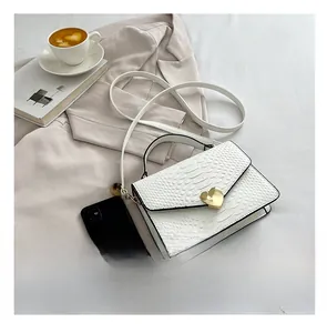 Size comparison between the white crocodile pattern handbag and a mobile phone