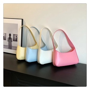 Row of pastel hobo bags in yellow, blue, white, and pink displayed on a minimalist shelf