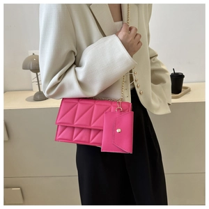 Detail der fuchsiafarbenen Stepptasche mit Kettengurt und passendem Münzetui