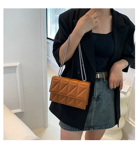 Detailed view of a brown quilted leather shoulder bag with chic silver chain strap