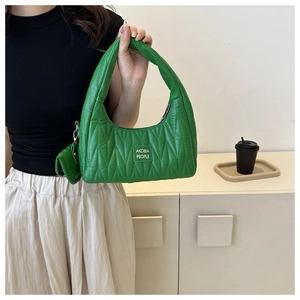 Détail du sac matelassé vert avec mini porte-monnaie et étiquette Akobia People
