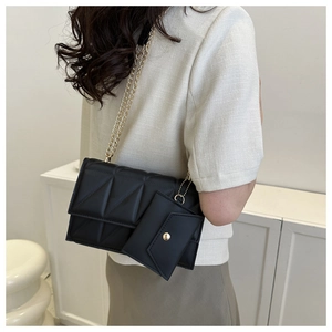 Detail der schwarzen Stepptasche mit goldener Kette und abnehmbarem Mini-Etui
