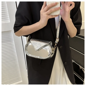Sac à bandoulière miroir argenté avec rabat motif serpent porté par un mannequin