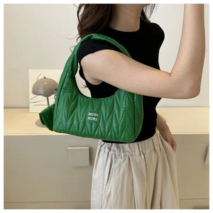 Détail du sac hobo vert émeraude avec texture matelassée en V et mini pochette