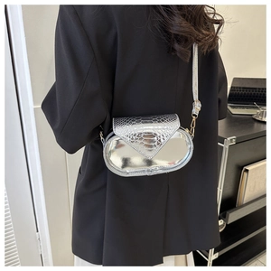 Détail du sac bandoulière ovale argenté avec motif crocodile embossé et fini métallique