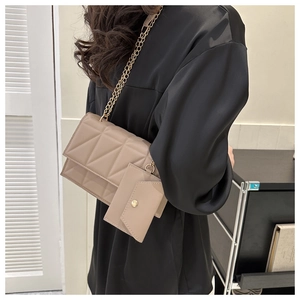 Gesteppte beige Umhängetasche mit Mini-Beutel und Kettenriemen über der Schulter