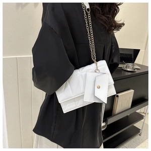 Detailaufnahme der weißen Stepptasche mit goldener Kette und passender Münzbörse
