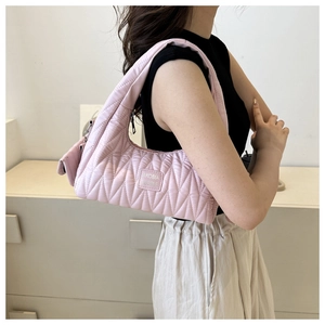 Vue détaillée du sac à bandoulière matelassé rose avec logo Akobia People