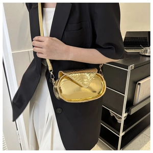 Détail du petit sac doré métallisé avec texture serpent et bandoulière chaîne