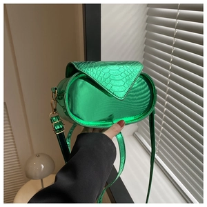 Détail du sac ovale vert métallisé avec texture crocodile et finitions dorées chic